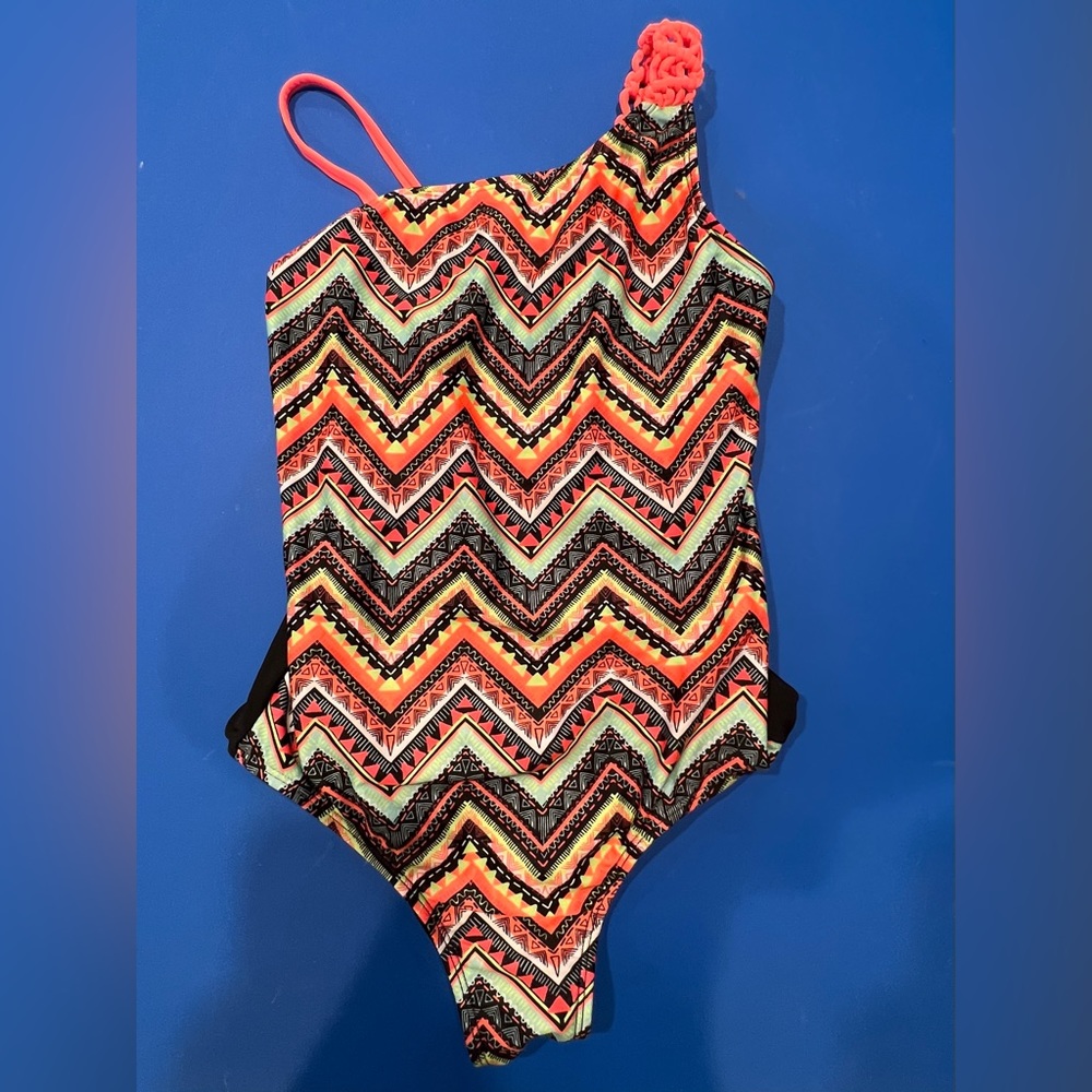 Girls one piece size large bathing suit with asymmetry at top. Zig-zag graphic.